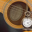 Acoustic guitar and cool old fashioned pocket watch