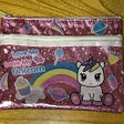 A pink pencil case with a white unicorn and the words “Love My Unicorn”