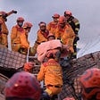 Firefighters rescuing a trapped Taiwan earthquake victim (Hualien City Government via AP)