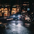 A black car at night on a city street