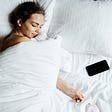 A women so addicted to her phone. She’s sleeping with it.