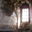 A bright window in a spooky stone hallway