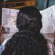 Backshot of woman reading newspaper