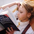 Young girl reading dictionary