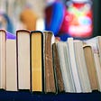 Colourful photo of a row of books, short end on, with a blurred background