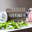 Do Something Creative Everyday on a wood board, includes a camera and mug