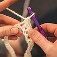 Person working with a crochet hook and yarn