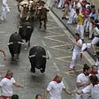Bulls and people are running in Santo Domingo Street during San Fermin festival, Pamplona
