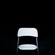White chair on black background