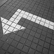 A left-turning arrow painted on the ground