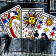three tarot cards in a jeans back pocket