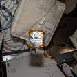 The Project Ascension pack of 25 Titanium plates wrapped in plastic floats aboard the International Space Station.