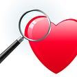 A large red heart being examined with a magnifying glass