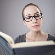Woman reading a book to review it