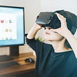 Woman at a desk wearing a Virtual Reality headset