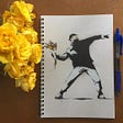 Cover of a Banksy journal and a bouquet of yellow roses