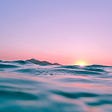 Beautiful sunrise over water; courtesy of Linus Nyland on Unsplash