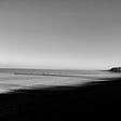 a empty beach/coastline in black and white