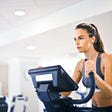 woman on treadmill with earbuds in