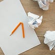 the image shows a plain piece of paper alongside a broken pencil and 4 balls of scrumpled-up paper