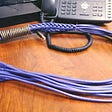 A purple braided cat/ethernet cable whip — The safe word is 404