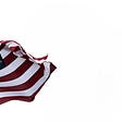 An American flag waves against a white background