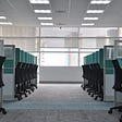 Photo of an office full of cubicles and windows.