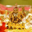 Small household idol of the goddess Lakshmi surrounded by flowers and other decorations