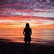 A woman at sunset on a beach silhouette.
