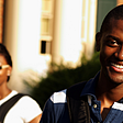 smiling college students on campus with backpacks