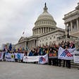 A group of people gather in front of the U.S. Capitol holding American Promise signs.