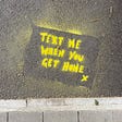 A piece of text saying ‘text me when you get home’ seen originally in Walthamstow and spray painted onto the road in protest.