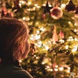 Girl looking at holiday decorations lit up.