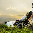 hospice patient in a wheelchair watching the sunrise with her caregiver