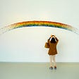 Woman photographing a rainbow