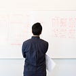 Man reviewing a set of wireframes on a whiteboard.