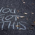 In chalk: “You Got This” written on blacktop