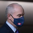 Canadian Conservative Party leader Erin O’Toole (he/him) wearing a face mask with a Canadian flag on it. Photo credit Adrian Wyld for Canadian Press