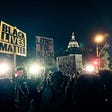 Photo taken at night of a group of Black Lives Matter protesters peacefully protesting