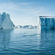 icebergs on body of water under blue and white sky at daytime