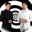 Thumbnail for the Unus Anus announcement video, featuring Ethan Nestor (left) and Mark Fischbach (right) standing in front of a black and white spiral.