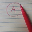 The grade A- handwritten with a red pen on notebook paper.