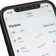 IMAGE: A smartphone displaying a Coinbase screen with the trends on several cryptocurrencies