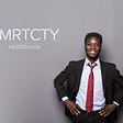 A man in a suit standing with his hands on his hips. There is a smart city Mississauga logo beside him.