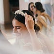 A female smiling while trying on a wedding dress