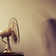 Fan blowing with a blurred image of a person.