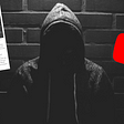 A black and white image of a hooded figure with a screenshot of a blog post on the left and the YouTube logo on the right.