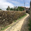 A typical section of the Camino Portuguese in smaller towns, complete with a dirt trail and stone walls