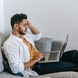 man browsing laptop at home