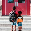 children stand outside of school’s closed doors